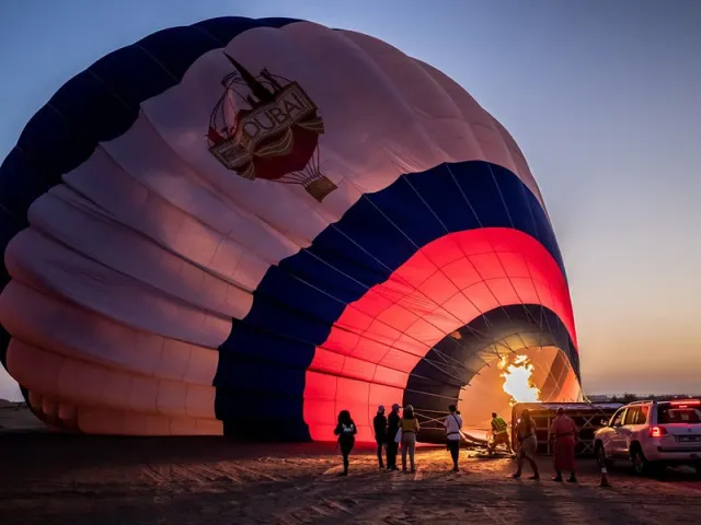 Passengers inside a hot air balloon basket over the desert