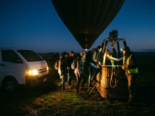 Boarding a hot air balloon basket before dawn